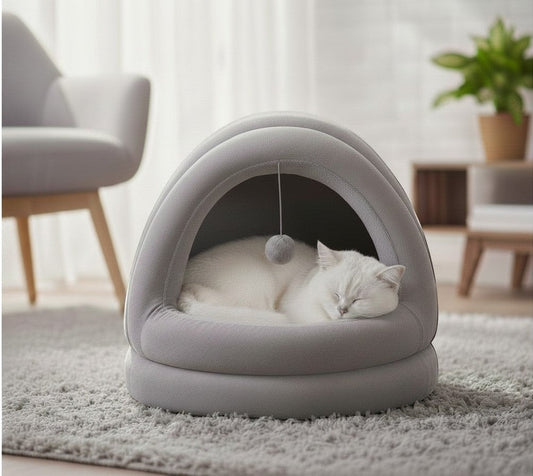 Cama cueva DELONEA de color gris para gatos con juguete colgante y un gato blanco durmiendo en su interior