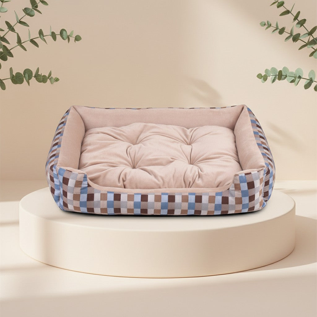 Cama para mascotas DELONEA SnoozePup con interior acolchado beige y exterior de tela a cuadros azules y marrones.